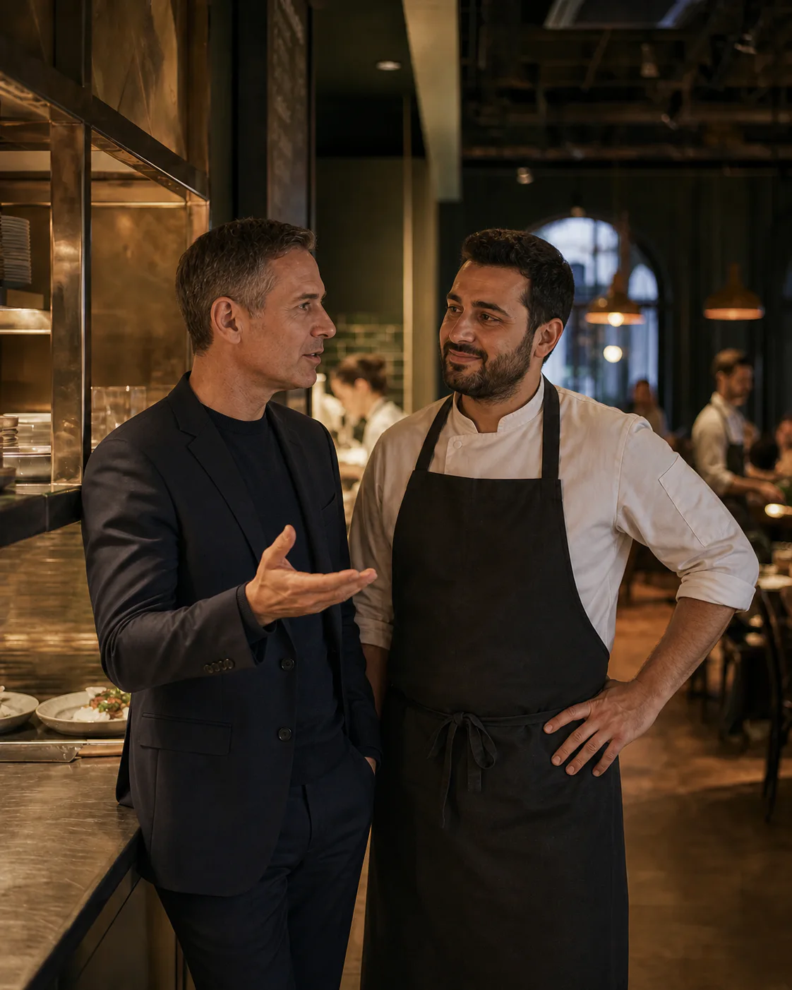 A restaurant technology adviser and restaurant owner discuss digital solutions in a restaurant kitchen